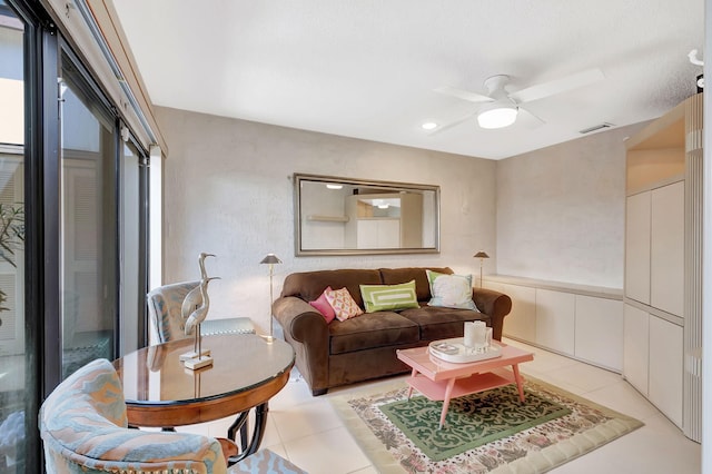 living area with a ceiling fan, visible vents, and light tile patterned flooring