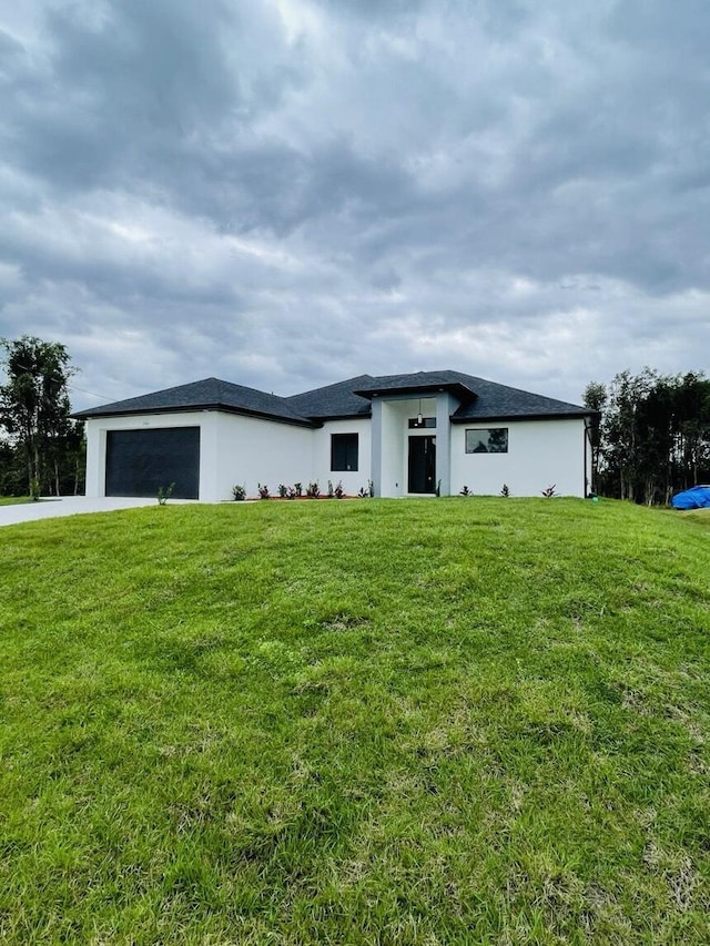 prairie-style home with a garage, driveway, and a front lawn