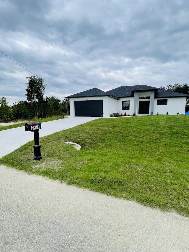 view of front facade featuring a front lawn, driveway, and an attached garage