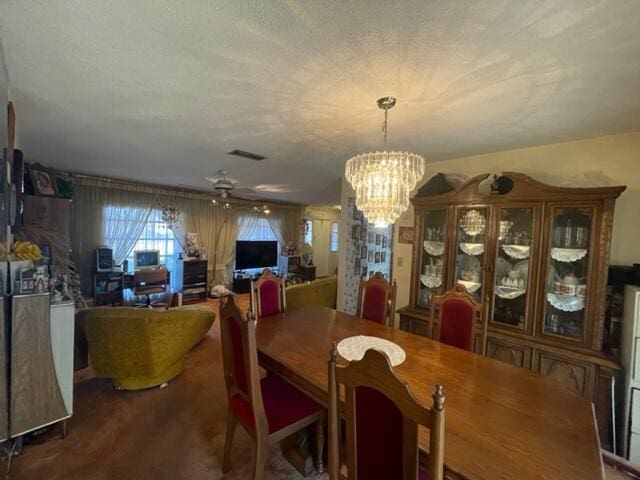 dining area with carpet floors, visible vents, and a notable chandelier