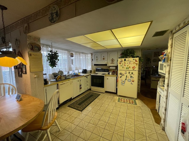 kitchen with light floors, visible vents, white cabinets, white appliances, and under cabinet range hood