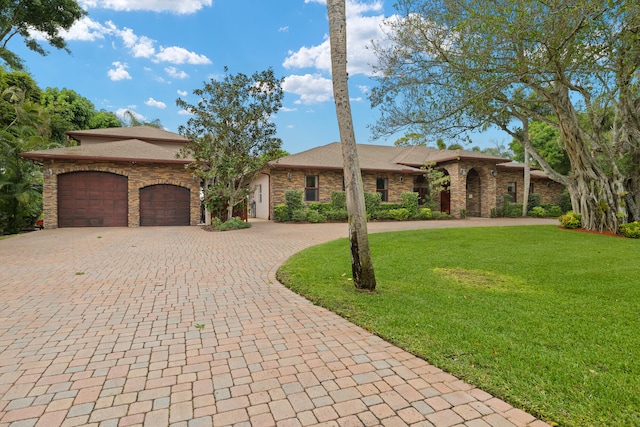 view of front of property featuring decorative driveway, a garage, and a front yard