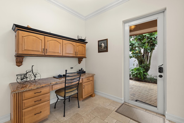 home office with crown molding, stone tile floors, baseboards, and built in study area