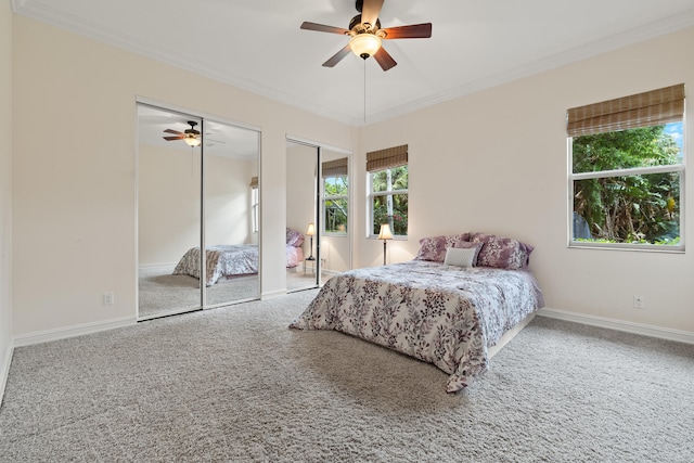 bedroom with crown molding, carpet, and two closets