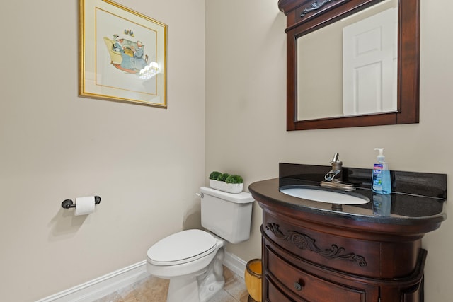 bathroom with tile patterned flooring, toilet, vanity, and baseboards