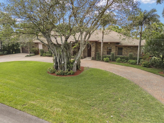 view of front facade with decorative driveway, a garage, a front lawn, and a shingled roof