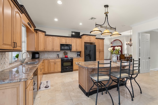 kitchen featuring visible vents, a kitchen bar, black appliances, a sink, and decorative backsplash