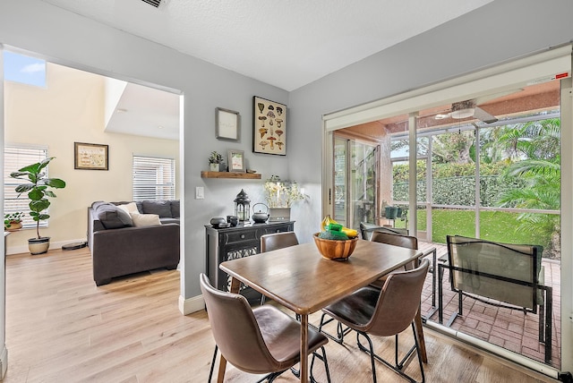 dining space with light wood finished floors, a wealth of natural light, and baseboards