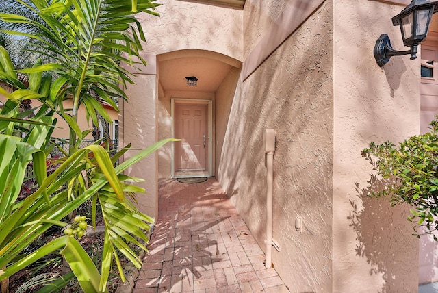 entrance to property featuring stucco siding