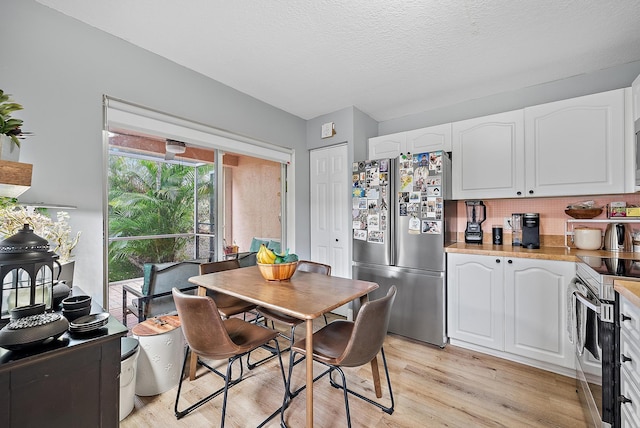 dining area featuring a textured ceiling and light wood-type flooring