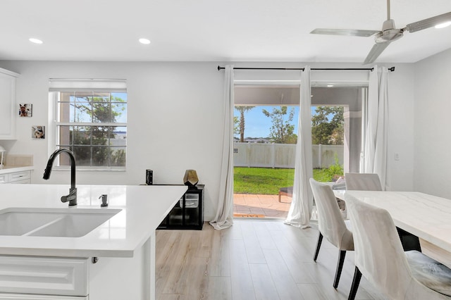 kitchen featuring recessed lighting, white cabinets, light countertops, and a sink