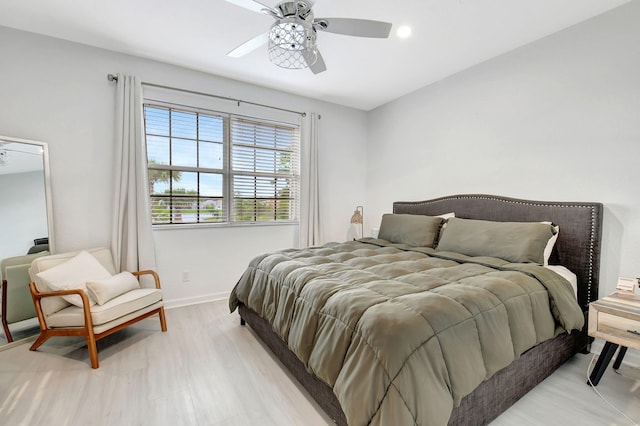 bedroom featuring a ceiling fan, light wood-type flooring, and baseboards