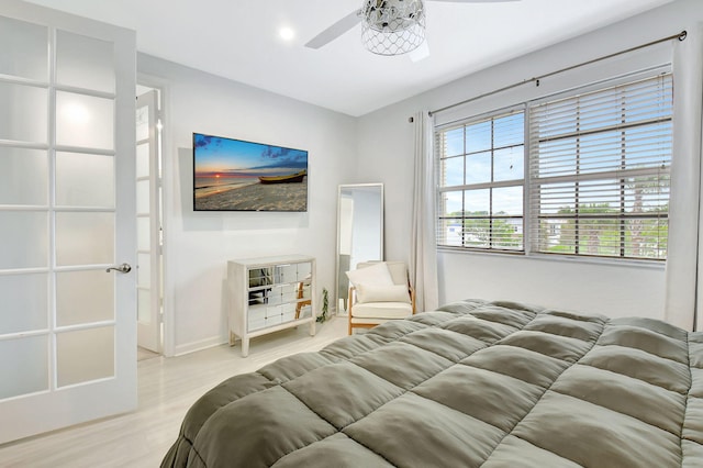 bedroom featuring baseboards, light wood-style flooring, and a ceiling fan