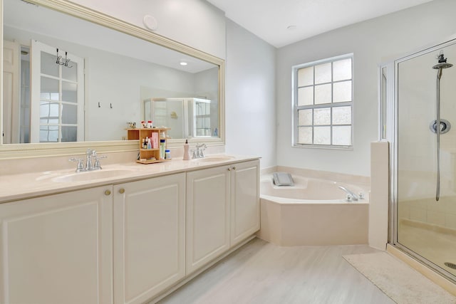 full bathroom with a garden tub, a sink, a shower stall, and double vanity