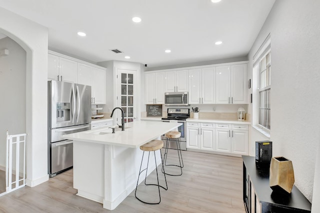 kitchen featuring appliances with stainless steel finishes, a sink, and white cabinets