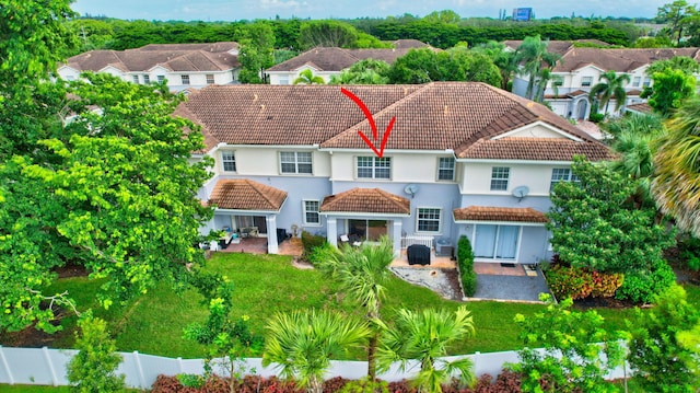 back of house with a tile roof, a lawn, a gazebo, a patio area, and a fenced backyard