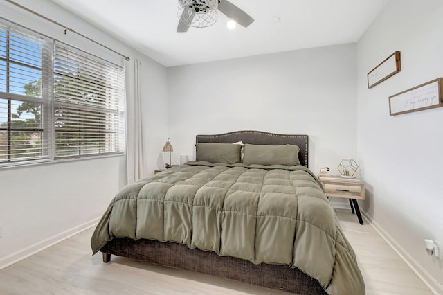 bedroom with light wood-style flooring, baseboards, and ceiling fan