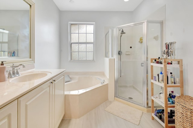 full bathroom with a shower stall, vanity, and a bath