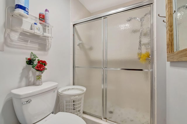 bathroom featuring a stall shower and toilet