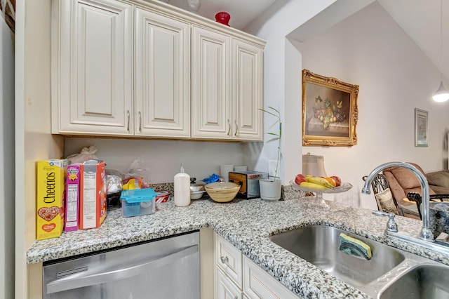 kitchen with a sink, light stone counters, and stainless steel dishwasher