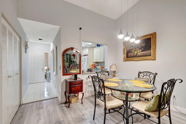 dining area featuring baseboards and light wood finished floors