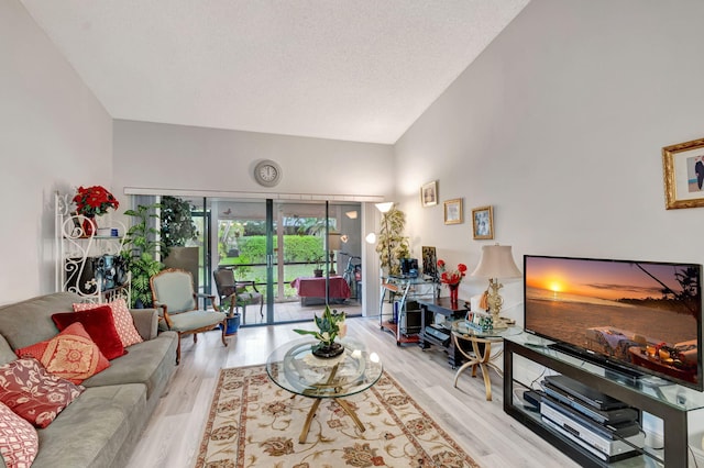 living room featuring a textured ceiling, high vaulted ceiling, and wood finished floors