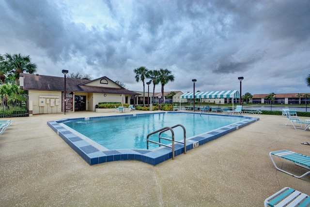 pool featuring fence and a patio