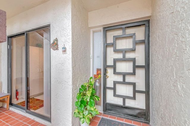 doorway to property featuring stucco siding