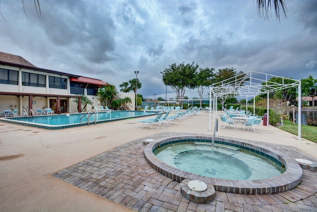 pool with a community hot tub and a patio area