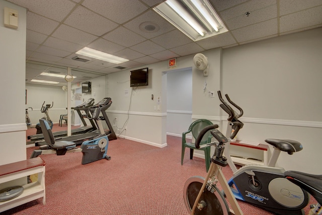 workout room featuring a paneled ceiling, carpet, visible vents, and baseboards