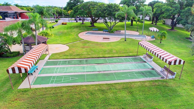 view of property's community featuring a yard and shuffleboard