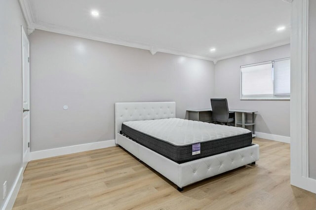 bedroom featuring baseboards, wood finished floors, and crown molding