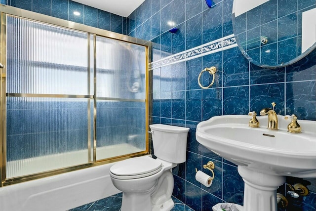 bathroom featuring shower / bath combination with glass door, tile walls, toilet, and tile patterned floors