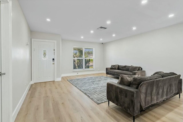 living area with recessed lighting, visible vents, light wood-style flooring, and baseboards