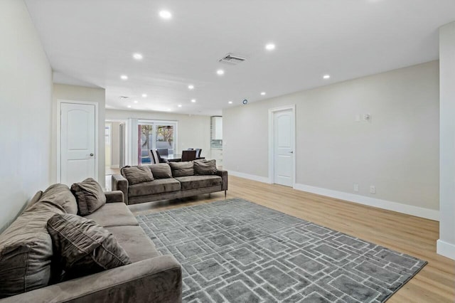 living room with recessed lighting, baseboards, visible vents, and light wood finished floors