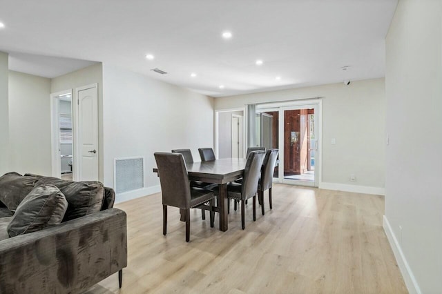 dining space featuring baseboards, visible vents, and light wood-style floors