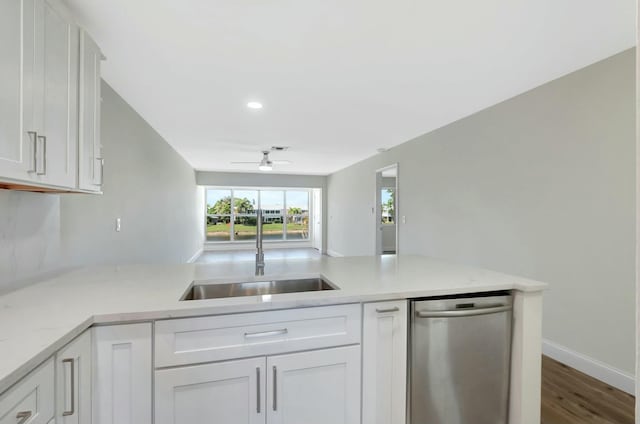 kitchen featuring white cabinets, a ceiling fan, a peninsula, stainless steel dishwasher, and a sink