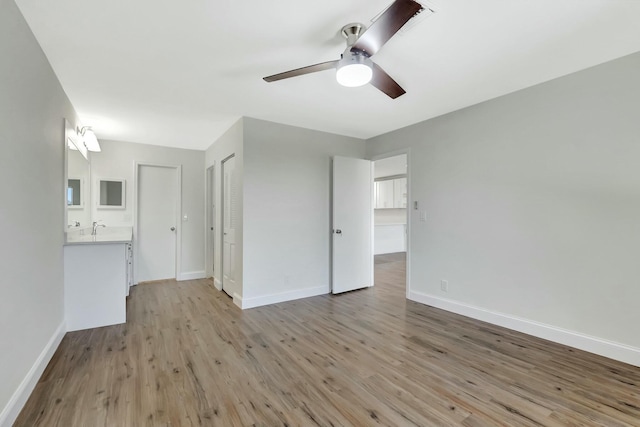 interior space featuring a ceiling fan, light wood-type flooring, and baseboards