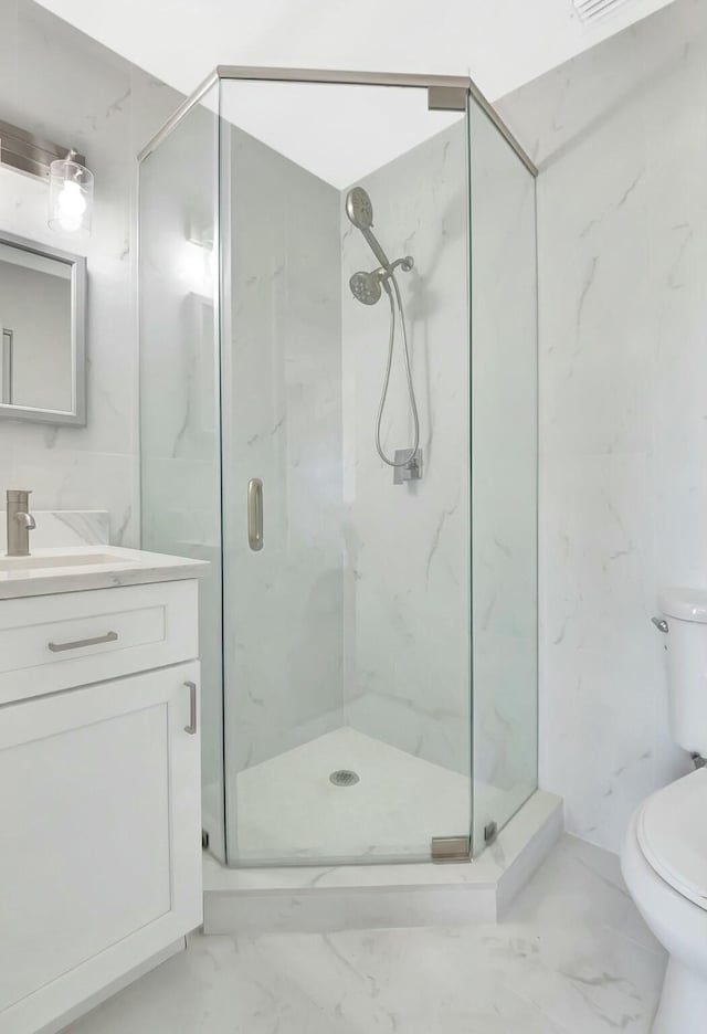 full bathroom with toilet, marble finish floor, a marble finish shower, and vanity