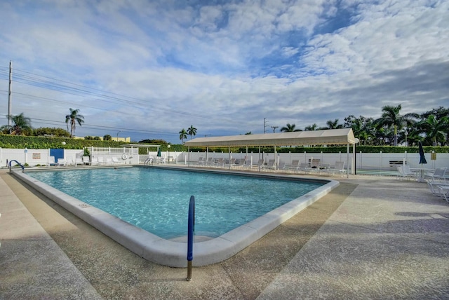 community pool featuring a patio area and fence