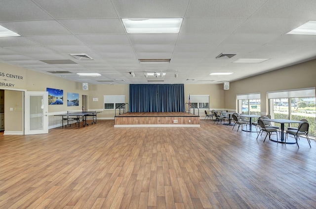 misc room with baseboards, visible vents, a drop ceiling, and wood finished floors