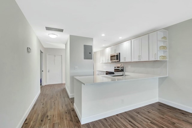 kitchen featuring electric panel, range with electric cooktop, visible vents, stainless steel microwave, and light countertops