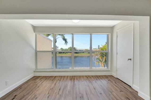 spare room featuring baseboards and wood finished floors