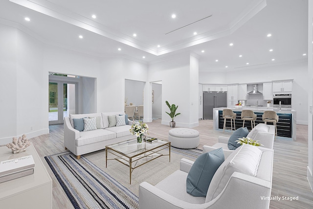 living area with ornamental molding, french doors, a high ceiling, and light wood-type flooring