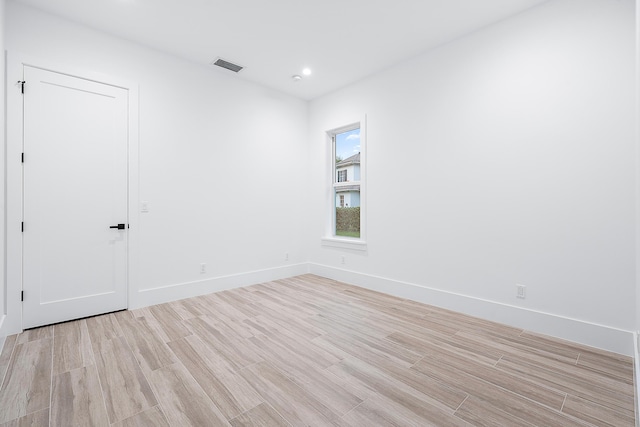 empty room with light wood-type flooring, baseboards, visible vents, and recessed lighting