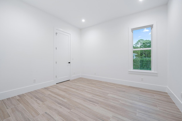 unfurnished room with light wood-type flooring, baseboards, and recessed lighting