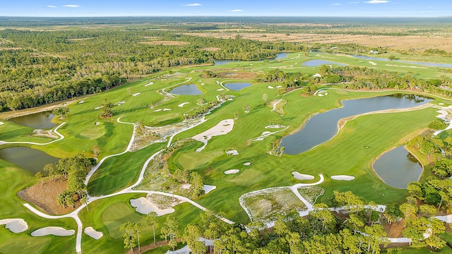 aerial view with a water view, golf course view, and a view of trees