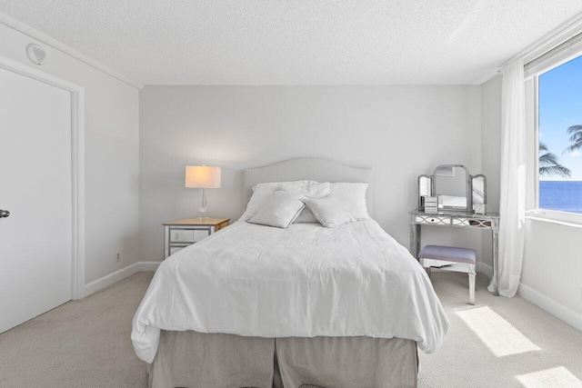 carpeted bedroom with baseboards and a textured ceiling