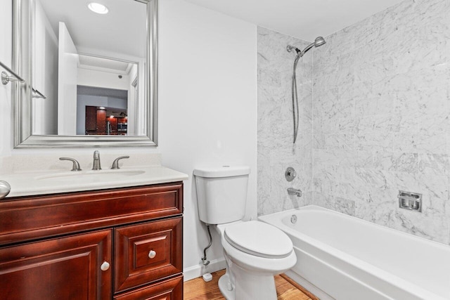 bathroom featuring shower / bathtub combination, toilet, wood finished floors, and vanity