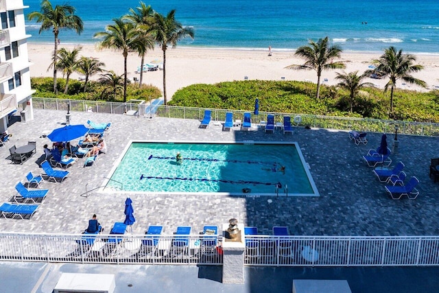 birds eye view of property with a water view and a beach view